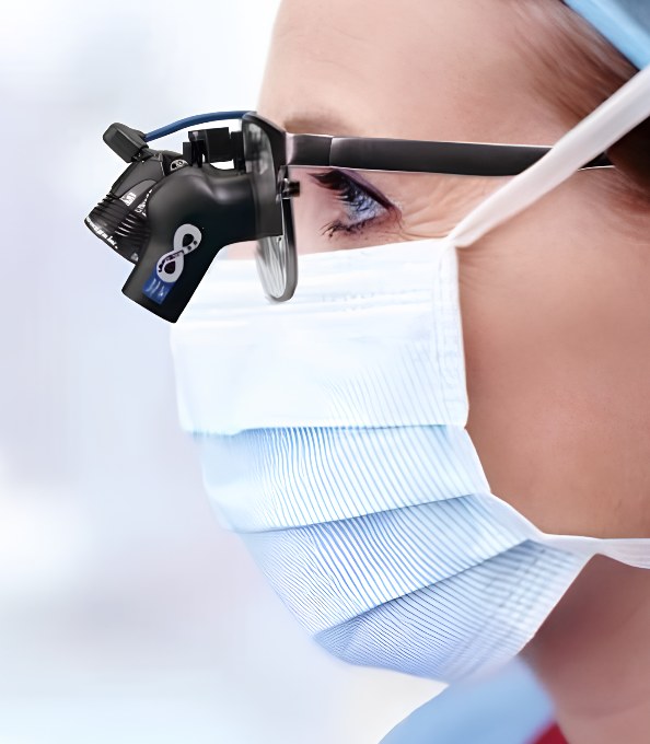 Clinician wearing Designs for Vision loupes with a mounted LED headlight in theatre